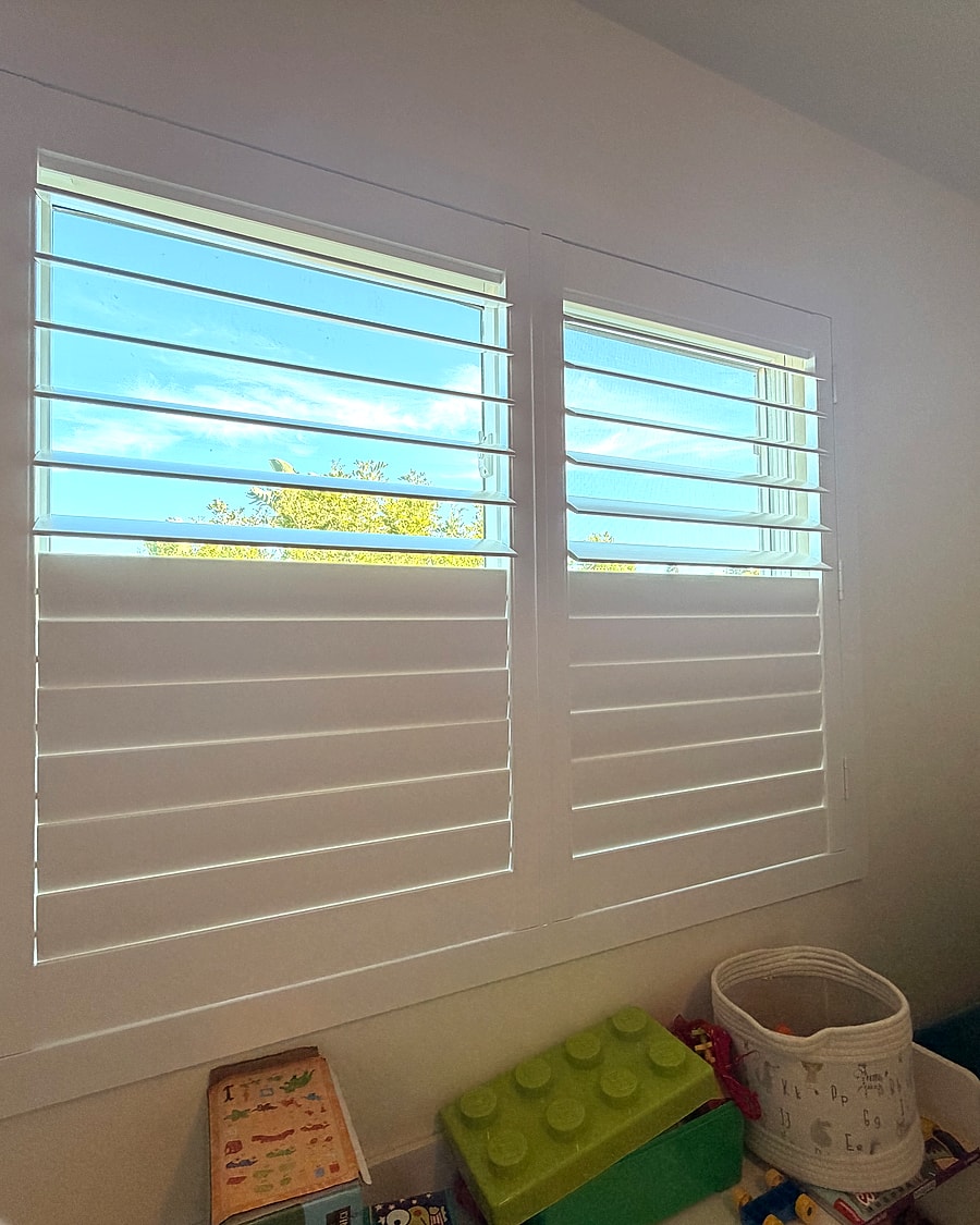 White plantation shutters installed on bedroom windows