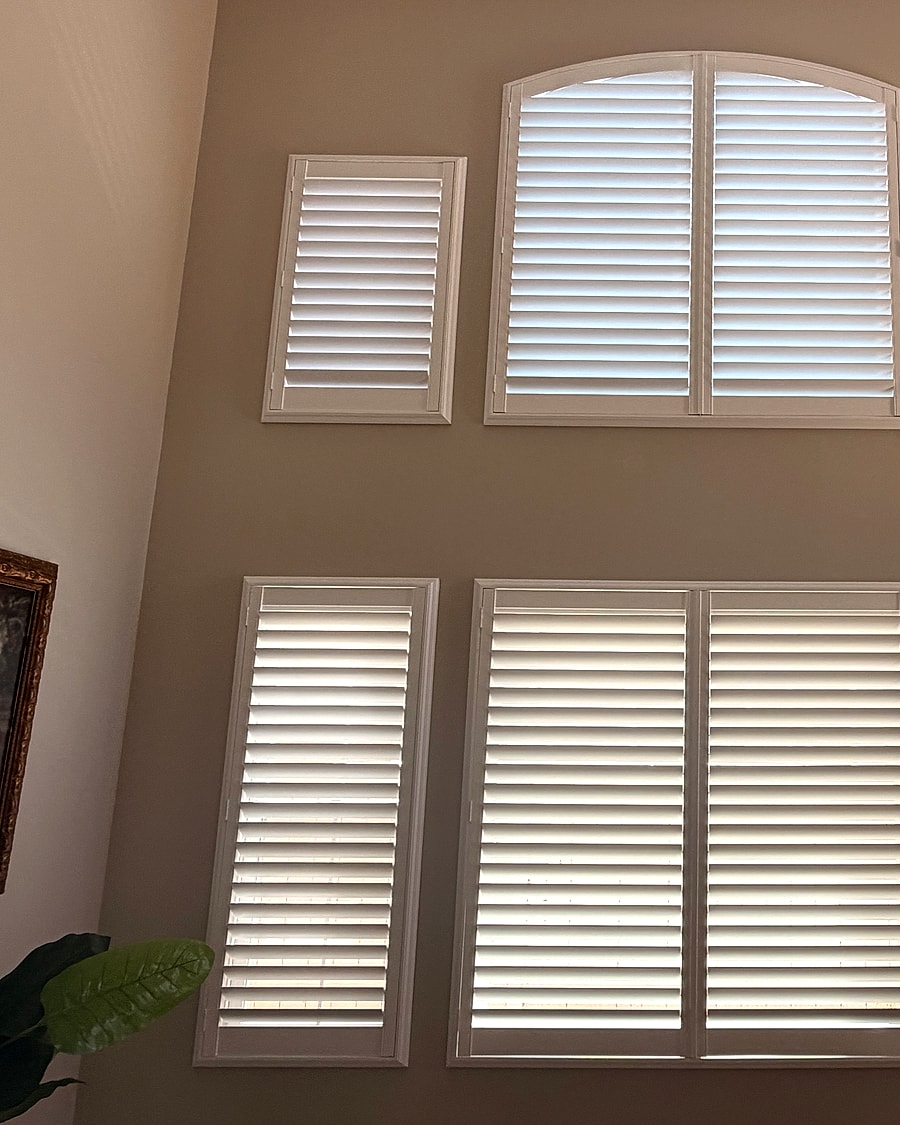 Two-story arched plantation shutters installed in a living room