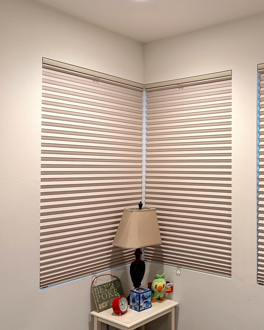 Full-height cellular shades installed on corner room windows