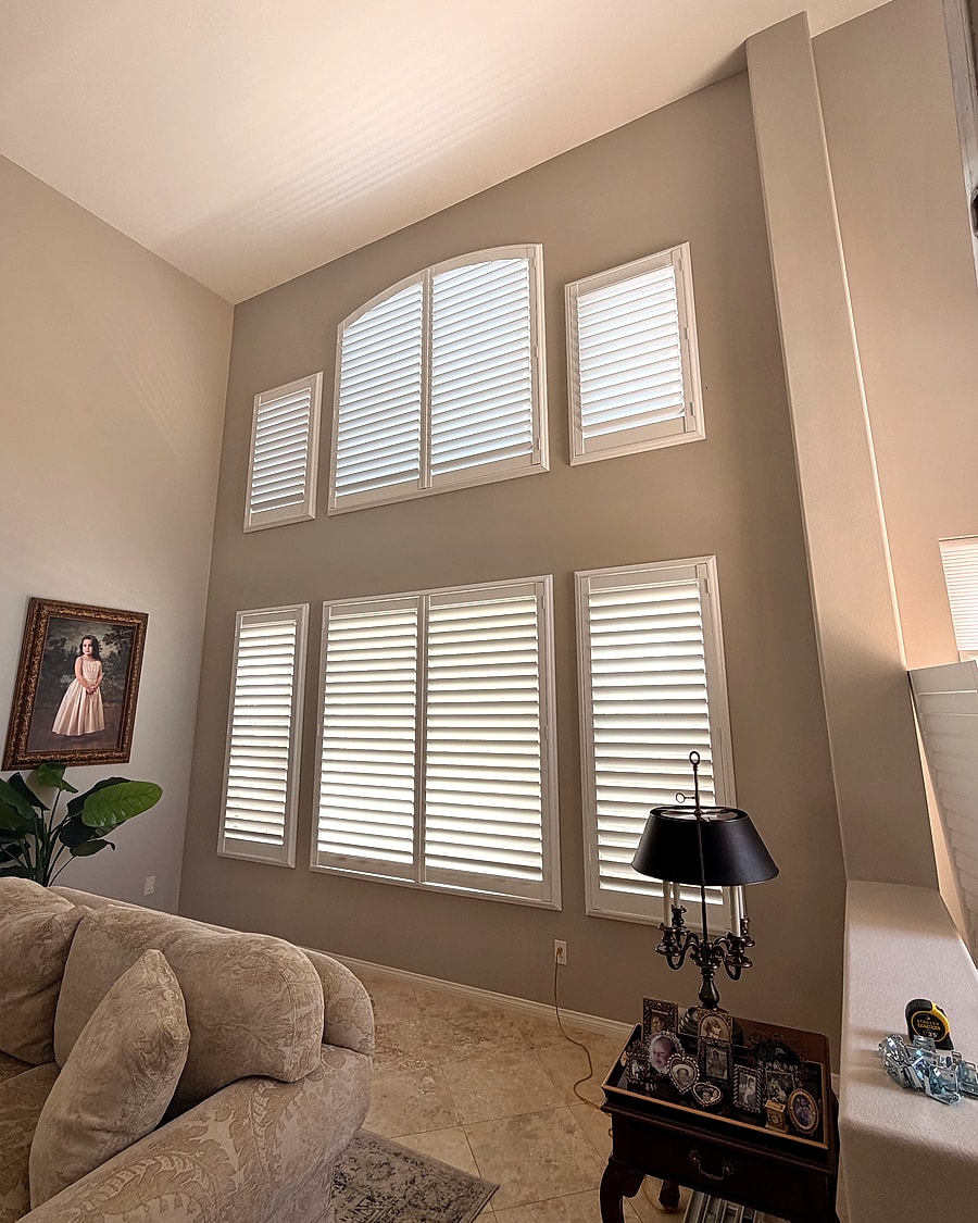 Two-story living room windows fitted with custom plantation shutters